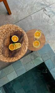 a wooden table with three glasses of orange slices at Casa Physis in Capitólio