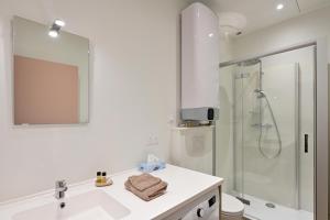 un bagno bianco con lavandino e doccia di Le nature ad Arras