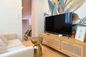 un soggiorno con TV a schermo piatto su un centro di intrattenimento in legno di Le nature ad Arras