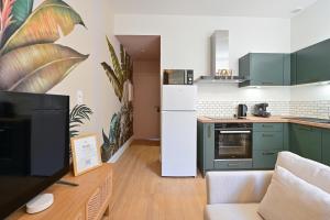 una cucina con mobili verdi e un frigorifero bianco di Le nature ad Arras