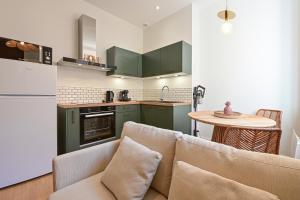 una cucina con armadi verdi, divano e tavolo di Le nature ad Arras Altre 8 foto