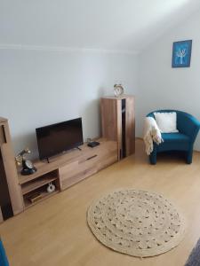 uma sala de estar com uma televisão e uma cadeira azul em Apartman Bepo em Gospić