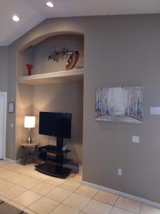 a living room with a television and a wall with a niche at Florida Villa in Kissimmee