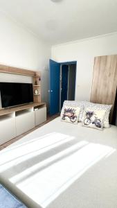 una camera con un grande letto e una TV a schermo piatto di Paradis a Vallauris