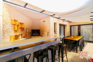 eine Bar in einem Restaurant mit einem Tisch und Stühlen in der Unterkunft Villa Kaz des sables in La Seyne-sur-Mer