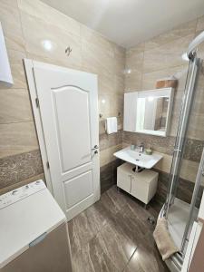 a bathroom with a white door and a sink at Apartments Majic Zivogosce in Živogošće