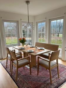 a dining room with a wooden table and chairs at Haus Ammertal in Peißenberg