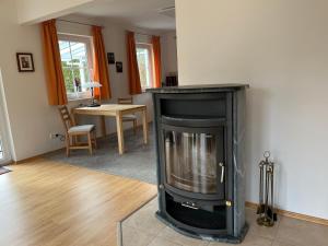 a living room with a fireplace and a table at Haus Ammertal in Peißenberg