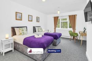 Brampton Grange的住宿－Elegant 3 Bedroom Detached House By Your Lettings Short Lets & Serviced Accommodation Peterborough With Free WiFi,Parking，紫色床单的客房内的两张床