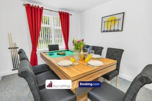 Brampton Grange的住宿－Elegant 3 Bedroom Detached House By Your Lettings Short Lets & Serviced Accommodation Peterborough With Free WiFi,Parking，用餐室配有木桌和红色窗帘