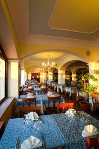 a restaurant with blue tables and chairs and a chandelier at Villaggio Hotel Lido San Giuseppe in Briatico