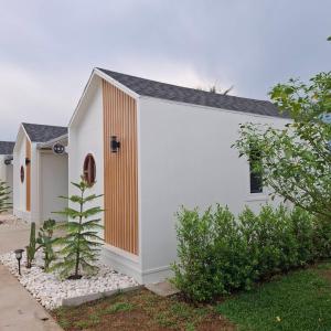a white house with a wooden door on it at นารา พรีเมียม รีสอร์ท @ชัยนาท in Chai Nat