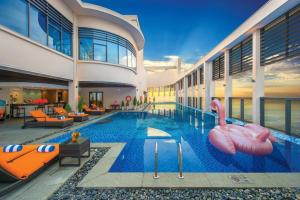 岘港Luxurious Ocean View Suites - My Khe Beach Front - Hinata Apartment的一座游泳池,里面设有可充气的火烈鸟