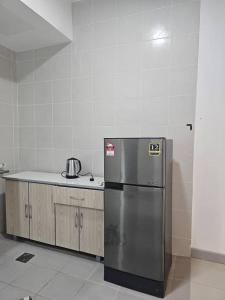 KTCC Drawbridge Cottage Kuala Terengganu - Homestay في كوالا ترغكانو: مطبخ مع ثلاجة ستيل ستانلس وكاونتر