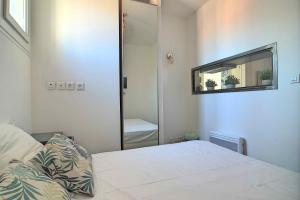 a small bedroom with a bed and a mirror at T3 2 chambres climatisation au calme 30 mètres du port in La Ciotat