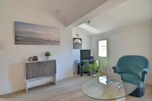 a living room with a green chair and a table at T3 2 chambres climatisation au calme 30 mètres du port in La Ciotat