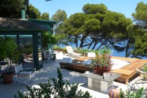 eine Terrasse mit einem Pavillon, Stühlen und Bäumen in der Unterkunft La Casa nel Bosco in Capri