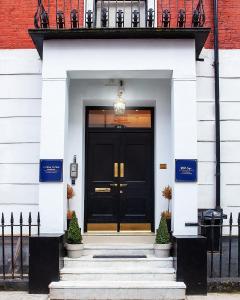 una puerta delantera negra de un edificio blanco en Putera Puteri Residence, en Londres