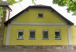 Casa amarilla con 3 ventanas y techo en (W)einHaus am See, en Rust
