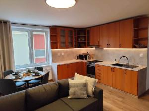 a living room with a couch and a table and a kitchen at Centrum Poprad Apartment in Poprad +6 photos