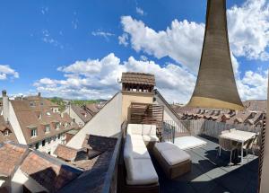 einen Dachbalkon mit Blick auf einen Turm in der Unterkunft Apartments Aarbergergasse in Bern