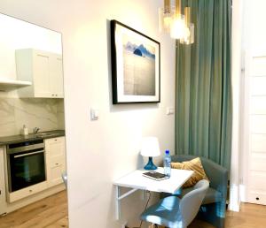 a small white table with a blue chair in a kitchen at CitizenA Studio no smoking in Radom