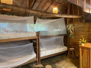 a room with two bunk beds in a cabin at Colibri hostal Minca Santa Marta in Minca