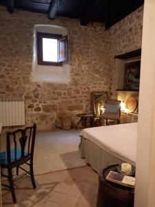 a bedroom with a bed and a window and a chair at La chiave del Tempo in Casteldilago