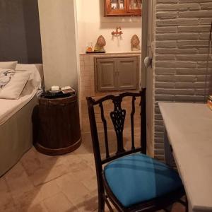 a room with a chair and a table and a bed at La chiave del Tempo in Casteldilago