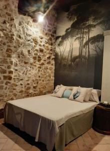 a bed in a room with a stone wall at La chiave del Tempo in Casteldilago