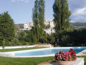a large swimming pool with flowers in a yard at La chiave del Tempo in Casteldilago