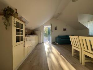 an attic kitchen with white cabinets and a blue couch at House Ana in Pučišća