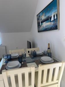 a dining room table with white plates and chairs at House Ana in Pučišća