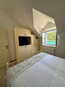 a bedroom with a large white bed with a window at House Ana in Pučišća