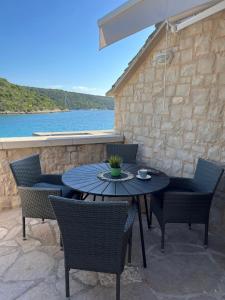 a table and chairs on a patio next to the water at House Ana in Pučišća +5 photos