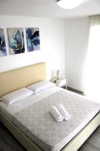 a bedroom with a large white bed with two towels at I Balconcini Sul Porto in Castellammare di Stabia