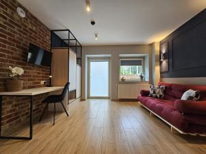 a living room with a red couch and a brick wall at Villa Evmerol in Wrocław
