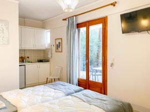 a bedroom with a bed and a kitchen at Nostos in Tolo