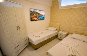 a room with two beds and a painting on the wall at Zeytindali Apart Hotel in Didim