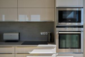 a kitchen with a stove and a microwave at Apartament z tarasem Panorama in Kołobrzeg +33 photos