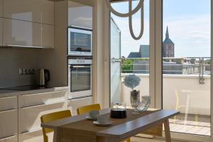a kitchen with a table and a view of a city at Apartament z tarasem Panorama in Kołobrzeg