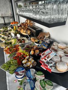 una mesa con muchos tipos diferentes de comida en ella en Hotel Efcannos Dornberg Carree en Vechelde