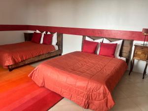 1 dormitorio con 2 camas y edredón rojo en Château de Crènille, en Chaumes-en-Brie