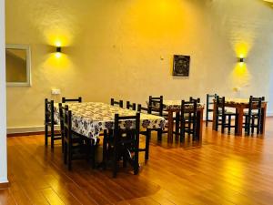 Royal Point Arugambay في آروغام باي: غرفة طعام مع طاولات وكراسي في غرفة