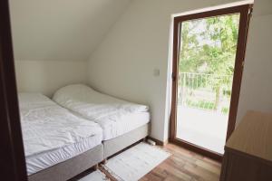 a bedroom with a bed and a door to a balcony at Różany Dom w Dominikowie in Dominikowo