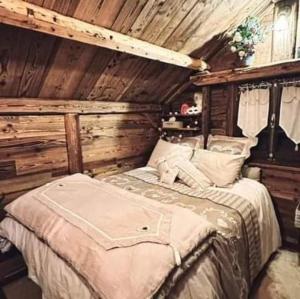 ein Schlafzimmer mit einem Bett in einer Holzhütte in der Unterkunft Amour & Chocolat in Sixt