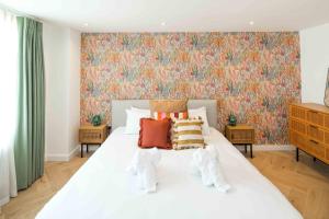 - une chambre avec un lit blanc et un papier peint floral dans l'établissement 2Bed 2Bath Stunning Shoreditch Apartment, à Londres