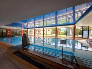 a large swimming pool in a building with a large building at Alpine Luxury Suite Beatenberg in Beatenberg