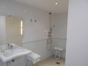 biała łazienka z prysznicem i umywalką w obiekcie Maison d'hôtes Le Manoir de Contres w mieście Contres