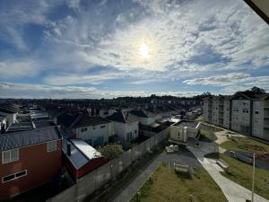 a view of a city with houses and a cloudy sky at Departamento nuevo excelente ubicación cómodo y amplió de 1 a 4 personas con estacionamiento in Puerto Montt